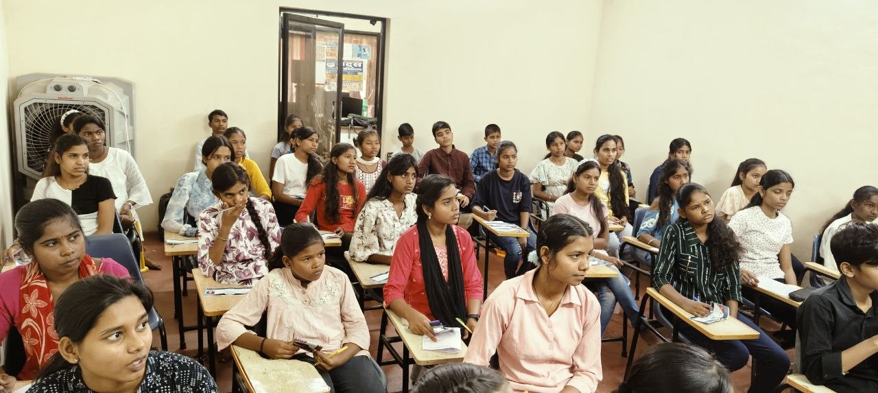 Female educator smiling confidently in a classroom setting with bright lighting